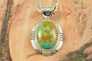 Genuine Manassa Turquoise set in Sterling Silver Pendant. This Turquoise is also referred to as King�s Manassa Turquoise. The Manassa Turquoise mine is located in Manassa, Conejos County, Colorado. Created by Navajo Artist Freddy Charley. Signed by the artist. Free 18